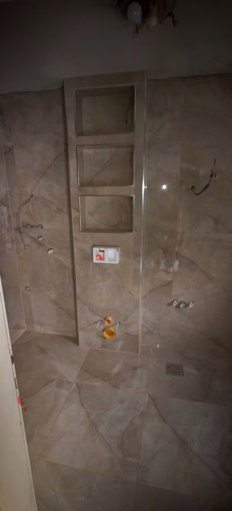 Keramičarski radovi u kupatilu na Novom Beogradu sa pločicama mermernog dezena i zidnim nišama.