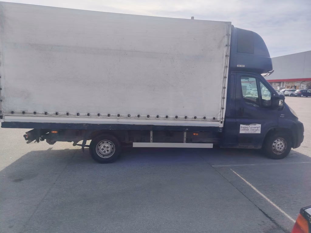Bočni pogled na teretno vozilo sa belom ceradom za selidbe u Novom Beogradu, Blokovi.