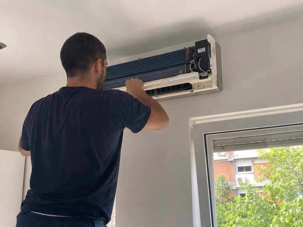 Servis klime Filmski grad, majstor radi na otvorenoj zidnoj jedinici