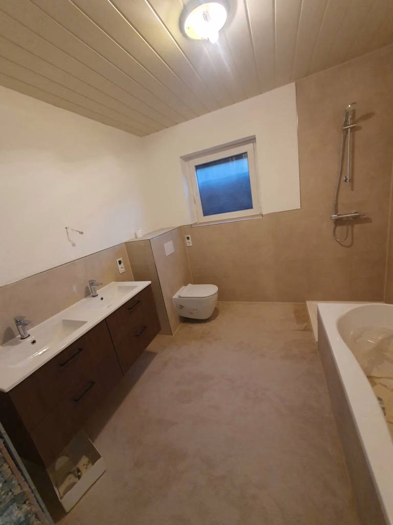 Prostrano kupatilo sa kadom, dva lavaboa, zidnom WC šoljom i tušem na Voždovcu.