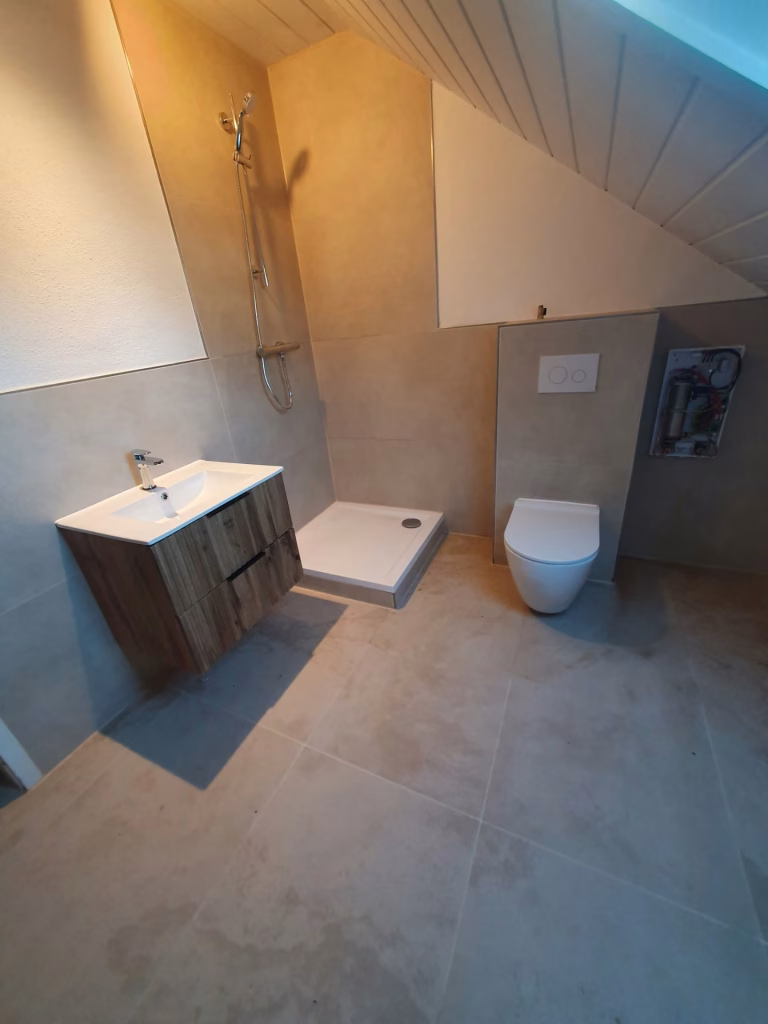 Potkrovno kupatilo sa tuš kadom, zidnom WC šoljom i lavabo ormarićem na Voždovcu.