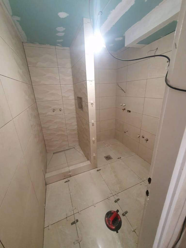 Popločavanje dve tuš zone sa podnim slivnicima i pripremljenim vodovodnim priključcima na Voždovcu.
